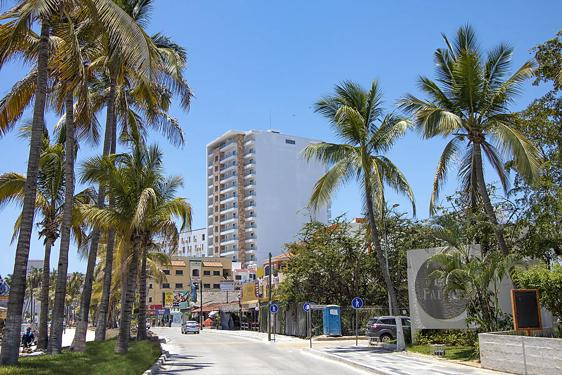 Hotel Pacific Palace Mazatlán sobre la avenida Sábalo Country, camino por la calle y balcones de habitaciones con vista a la ciudad